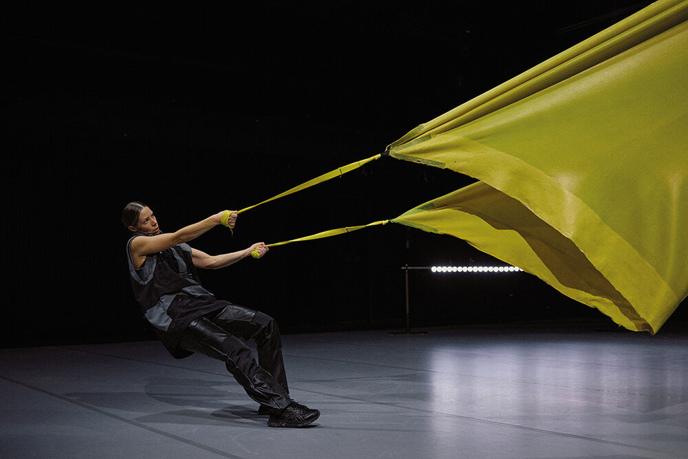 Eine Person hält eine Art großes sich blähendes Segel